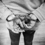 https://www.pexels.com/photo/black-and-white-image-of-person-in-handcuffs-37732198/